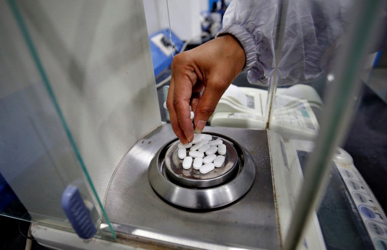 Image: A pharmacist weights acetaminophen tablets at a pharmaceutical company in Ahmedabad, India, on March 4, 2020.