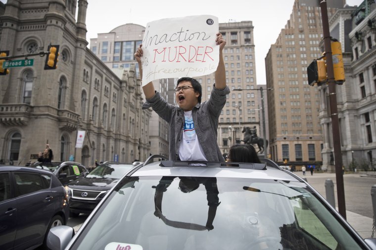 A protester calls for officials to release people from jails, prisons, and immigration detention centers in response to the coronavirus, as he and others block traffic outside City Hall in Philadelphia on Monday.