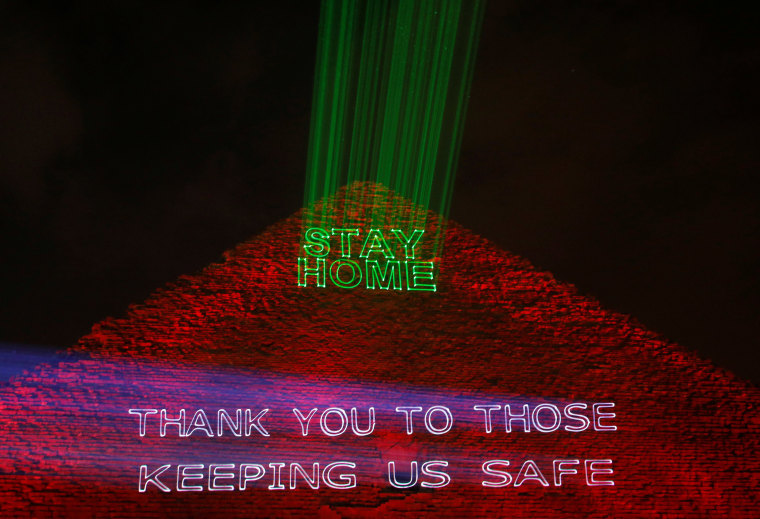 Image: The pyramid of Khufu, the largest of Egypt's Giza pyramid complex, is illuminated with text encouraging people to stay home on Monday.