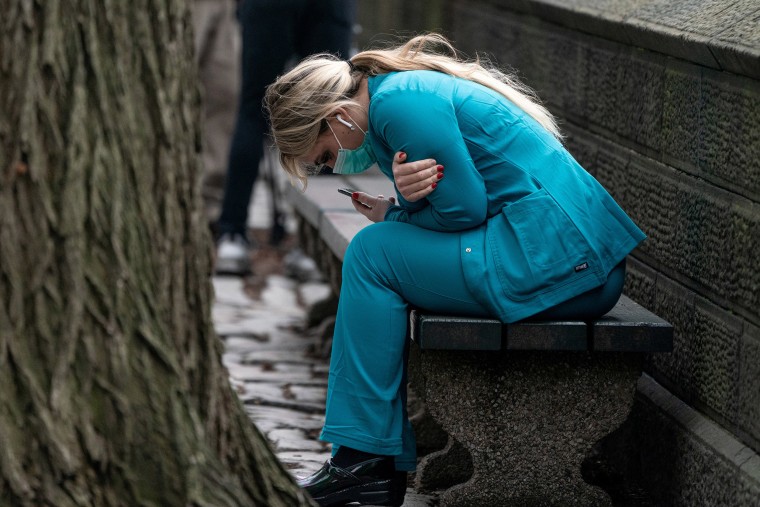 Image: A healthcare worker sits on a bench near Central park in the Manhattan borough of New York City