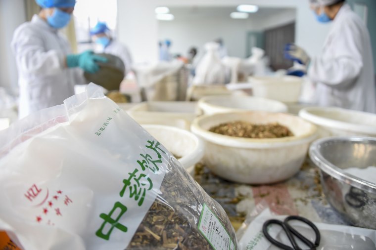 Image: Traditional Chinese medicine pharmacists prepare herbs to produce doses of TCM concoctions to help combat the novel coronavirus epidemic at Xiaogan Chinese Medical Hospital in Xiaogan City, central China's Hubei Province