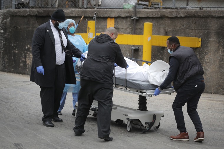 Workers wheel a deceased person outside of Brooklyn Hospital Center during the coronavirus disease (COVID-19) outbreak in the Brooklyn borough of New York