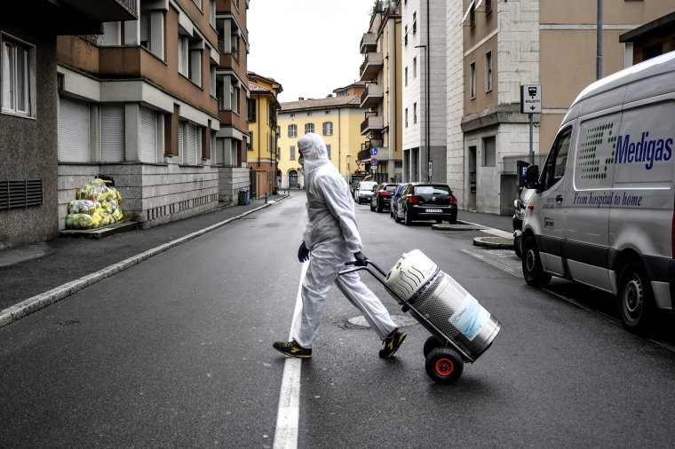 A Medigas employee delivers medical oxygen tanks Tuesday to coronavirus patients who are being treated at home in Bergamo, one of the hardest-hit areas in northern Italy. 