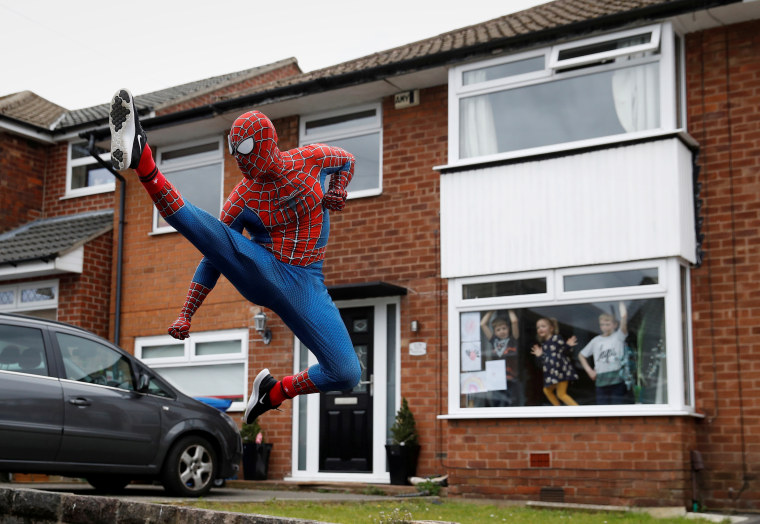 Jason Baird performs for local children dressed as Spider-Man in Stockport, Britain.