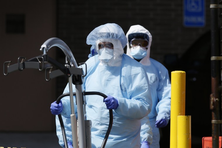 Image: Workers in protective equipment outside Wyckoff Heights Medical Center in Brooklyn during outbreak of the coronavirus disease (COVID-19) in New York