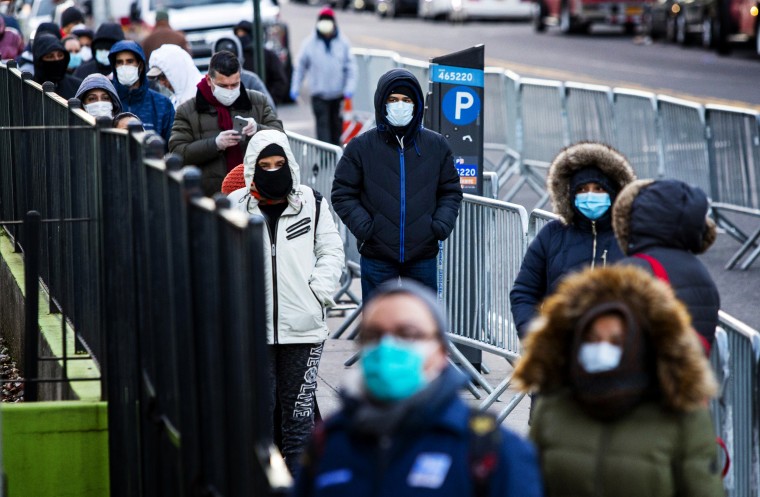 Image: People line up to get a coronavirus test at Elmhurst Hospital in Queens, N.Y., on March 24, 2020.