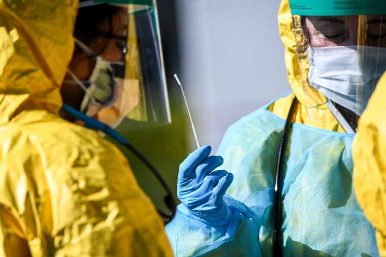 Image: Health workers in personal protective gear at a coronavirus testing site in Jericho, N.Y., on March 24, 2020.