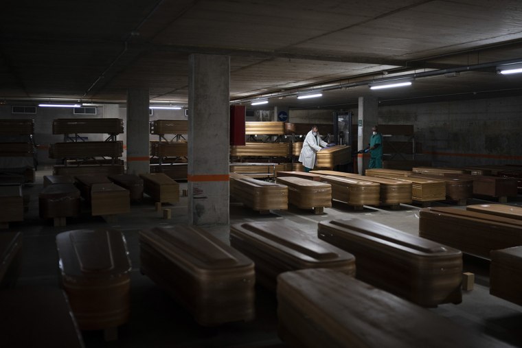 Image: Coffins carrying the bodies of people who died of coronavirus are stored waiting to be buried or incinerated in an underground parking lot at the Collserola funeral home in Barcelona, Spain on Thursday.
