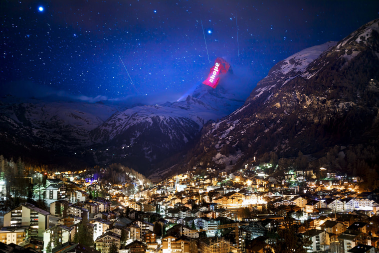 Image: Switzerland's iconic Matterhorn mountain in the alpine resort of Zermatt is illuminated by Swiss light artist Gerry Hofstetter to send a message of hope.