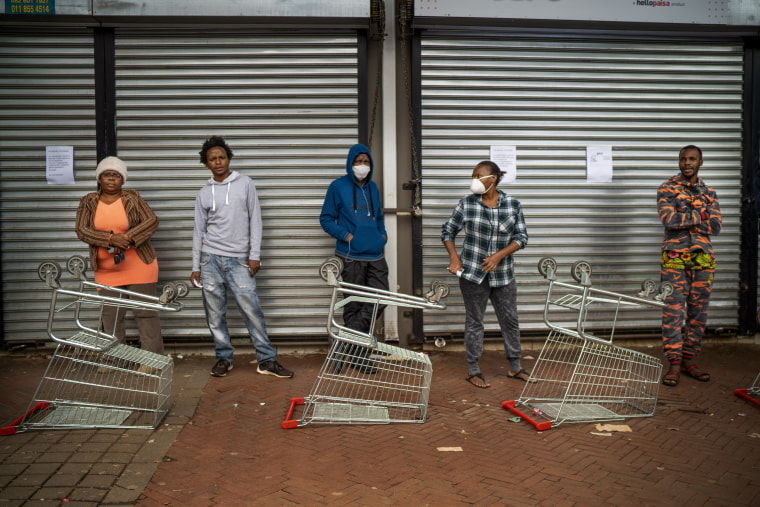 Shoppers wait to enter a grocery store in Johannesburg on April 3, 2020.