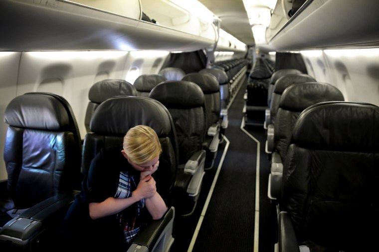 Image: A flight attendant waits for the departure of a one-passenger flight between Washington and New Orleans on April 3, 2020. The one passenger? The photographer.