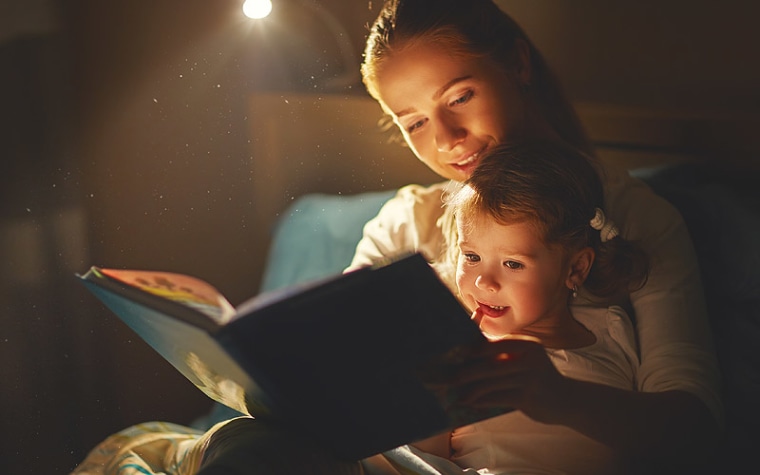 Mother reads to daughter.