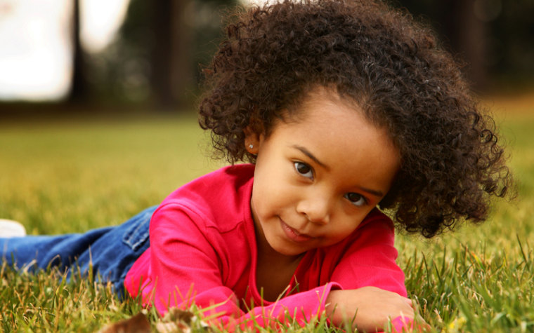 Young girl lying in grass.