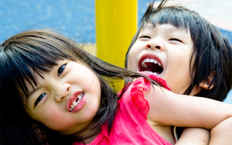 Two young children fight on playground.