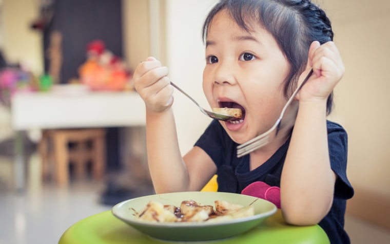 Young girl eats pancakes.