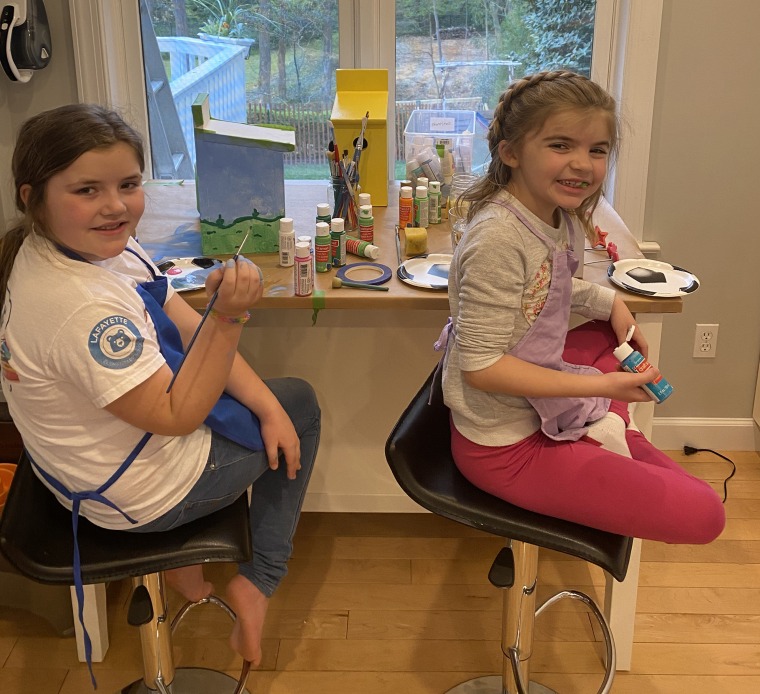 Brian Oliver and his daughters, Madeline and Emma, are assembling birdhouse kits, which they're sending to loved ones. Making something to share with others helps to keep them occupied.