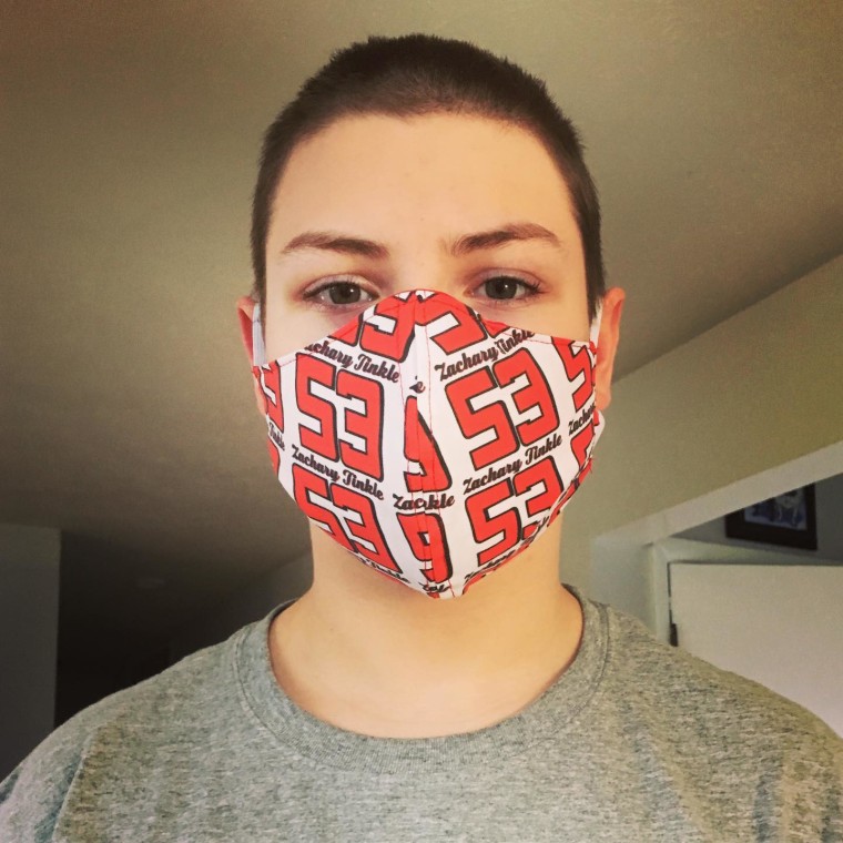 A teen wears a mask with the number 53.