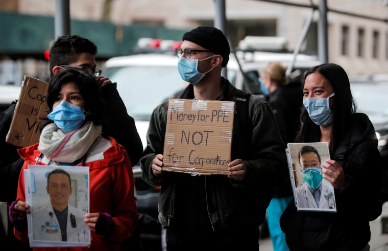 Image: Healthcare workers at Mount Sinai Hospital hold photos of sick colleagues at a protest demanding more PPE in New York on April 3, 2020.
