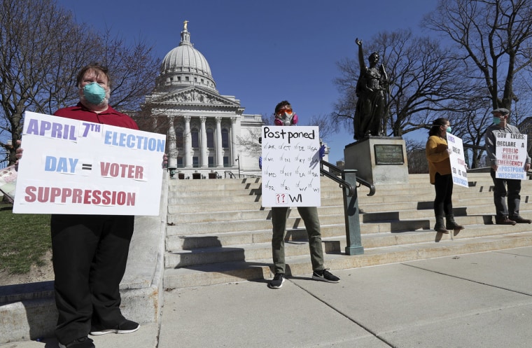 Image: A group with C.O.V.I.D., Citizens Outraged Voters in Danger, including, from left, Ron Rosenberry Chase and Jim O'Donnell, protest while wearing masks outside the State Capitol during a special session regarding the spring election in Madison, Wis