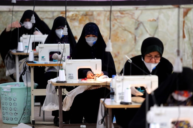 Image: Iranian women, members of the Basij paramilitary organisation, make face masks and other protective items at a mosque in the capital Tehran on Sunday.