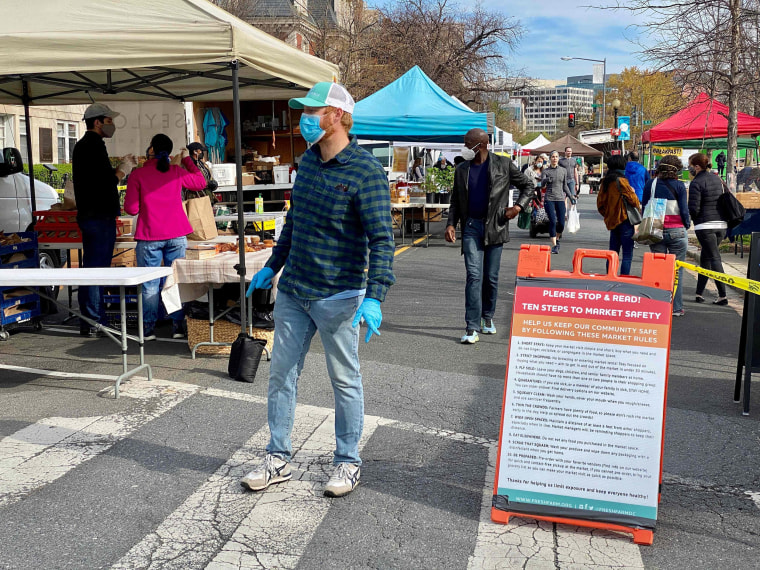 Image: Customers wearing masks walk through the Dupont Circle Market in Washington