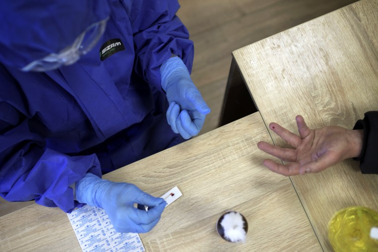 Image: A medical worker runs a blood test for coronavirus antibodies in Lviv, Ukraine, on April 1, 2020.