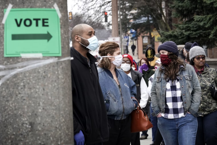 Image: Voters in masks wait to vote in Wisconsin's primary election in Milwaukee on April 7, 2020.