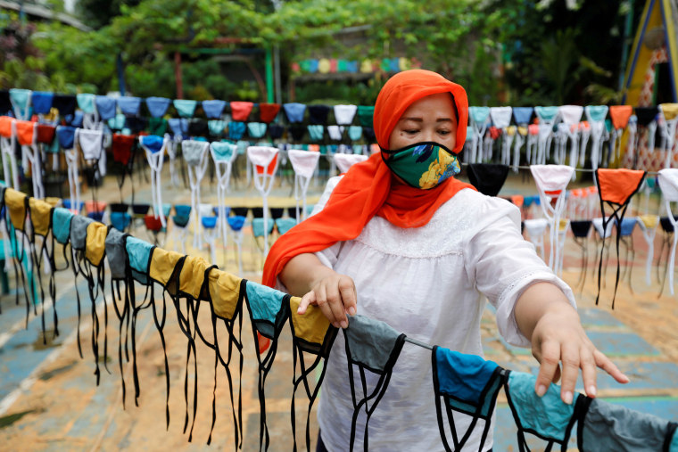 Image: A woman puts cloth face masks on a string to dry before distributing it for free around the neighbourhood, amid the spread of coronavirus disease (COVID-19) outbreak, in Tangerang, on the outskirts of Jakarta, Indonesia