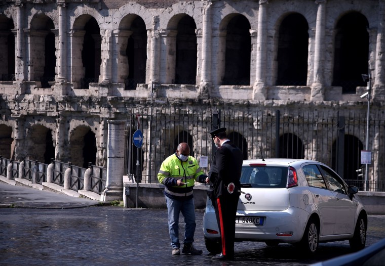 Image: An Italian Carabiniere controls a driver by the Teatro di Marcello in Rome on April 8, 2020 during the country's lockdown aimed at curbing the spread of the COVID-19, caused by the novel coronavirus.