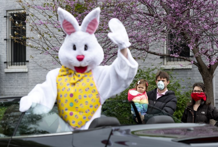 Image; Richard Lucas, dressed as an Easter bunny, waves to families in Washington, D.C., on April 12, 2020.