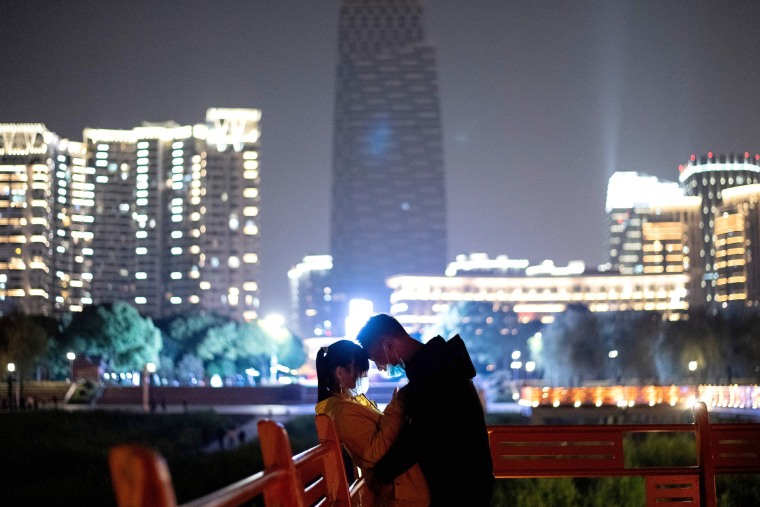 Image: A couple embrace near the Yangtze River in Wuhan on April 12, 2020.