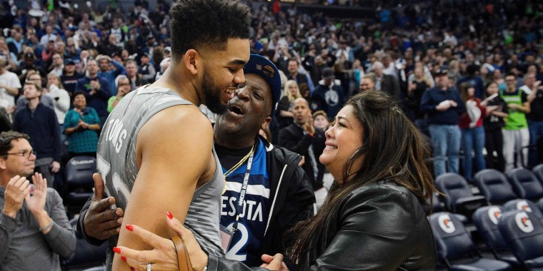 Karl-Anthony Towns hugs his parents, Karl and Jackie, after winning a game against the Denver Nuggets on April 11, 2018.