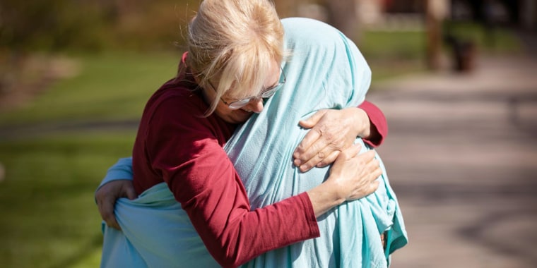 Cheryl Norton, of Blue Ash, hugs her daughter, Kelsey Kerr, 28, an ICU nurse at Christ Hospital and working the front lines during the new coronavirus pandemic, Friday, April 3, 2020. Norton so much wanted to hug her, so she put a sheet over her so she could hold her tight, just for a moment. After this hug, Cheryl dropped the covering in the garage. It will lie there for three days before she washes it in hot soapy water. And she, of course, washed her hands. An involved process for a hug.