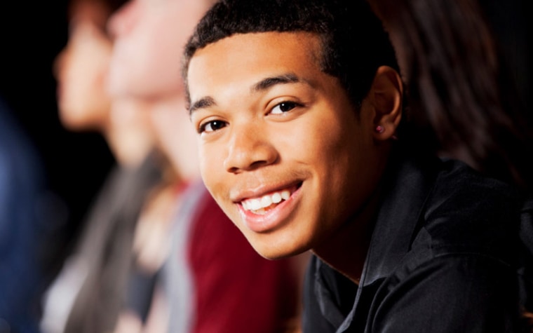 Teenage boy looks to side smiling