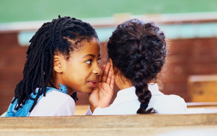 Elementary school girls whisper secrets in class