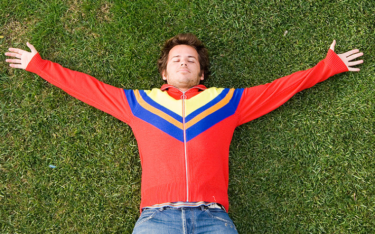 Teen boy laying on the grass