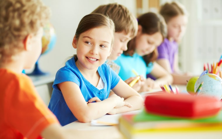 Girl in blue shirt talks to classmate in homeroom