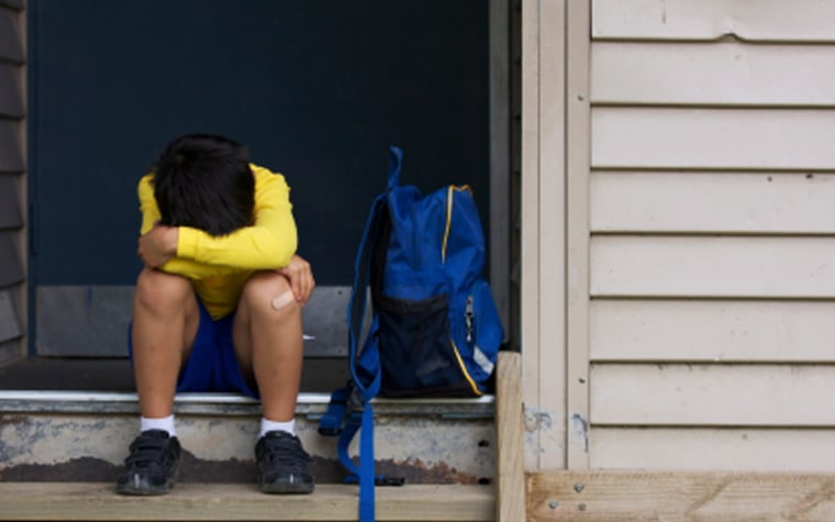 Hurt boy hides his face between his knees