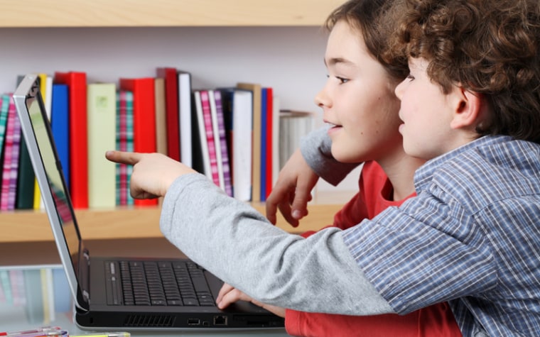 Two kids use a laptop