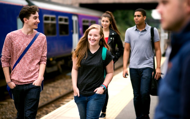 Teens talking while walking off of train platform