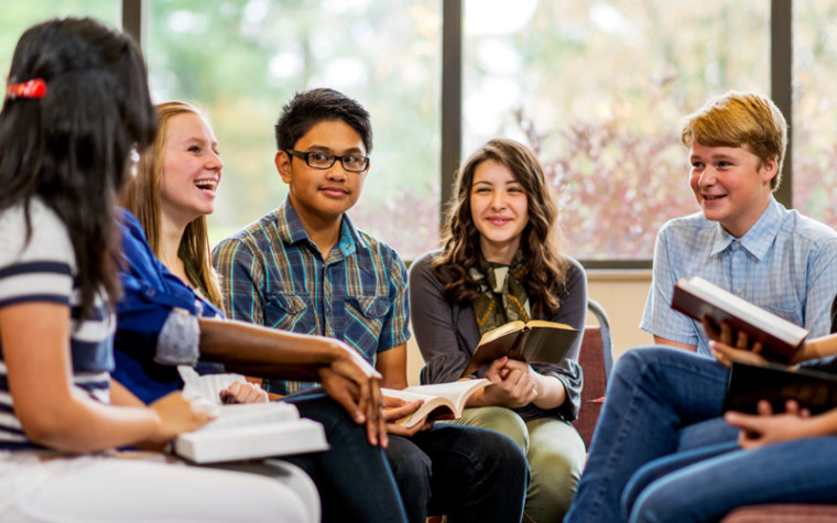 Kids sitting in circle while reading books in library