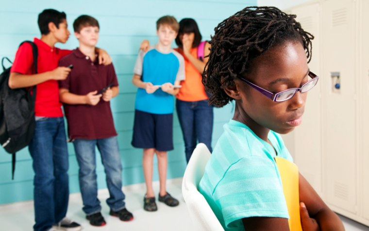 Four kids teasing girl in blue striped shirt