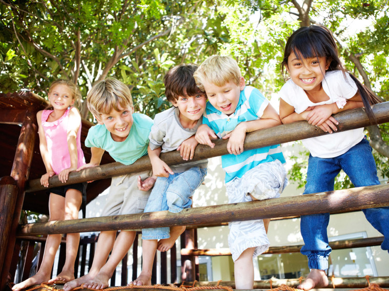 Group of five kids hanging on a fence