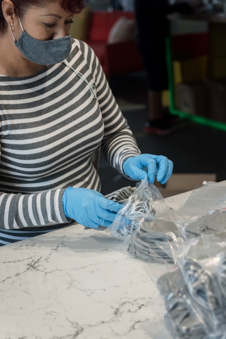 A Hedley &amp; Bennett employee packaging masks to be shipped out.