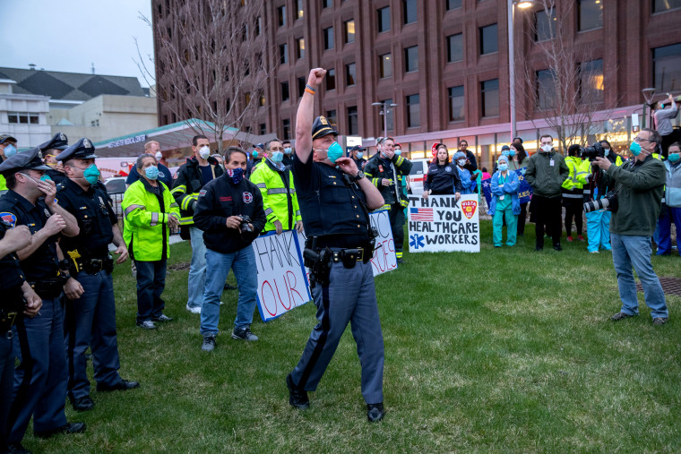 Image: A police officer leads a cheer for healthcare workers outside of Westchester Medical Center in Valhalla, N.Y, on April 14, 2020.