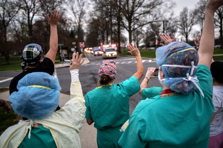 Image: Hospital workers cheer first responders as they pass Westchester Medical Center in a caravan of sirens and lights in Valhalla, N.Y., on April 14, 2020.