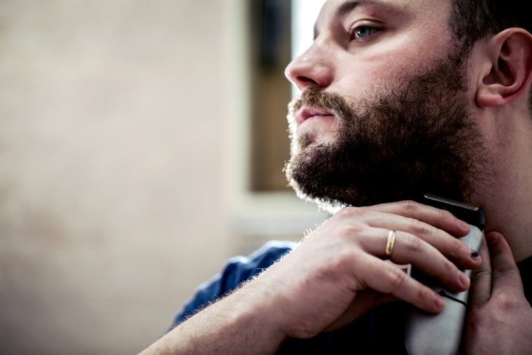 Young man shaving beard