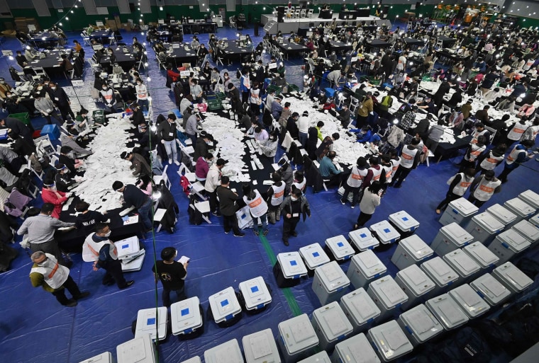 Image: South Korean election officials sort voting papers for ballot counting in the parliamentary elections at a gymnasium in Seoul