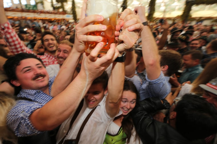 Image: Revelers strain to receive the first 1-liter-mug of beer during the opening weekend of the 2019 Oktoberfest