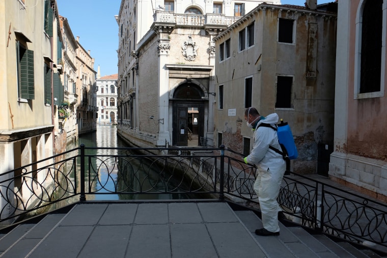 Image: A man sanitises a bridge as the spread of the coronavirus disease (COVID-19) continues in Venice, Italy